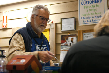 a ReStore volunteer cashier assists a woman with her purchase