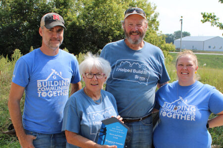 Longtime volunteers Steve and Kaye Cook receive the John Homstad Volunteer of the Year award from Habitat team members Jason and Brittany.