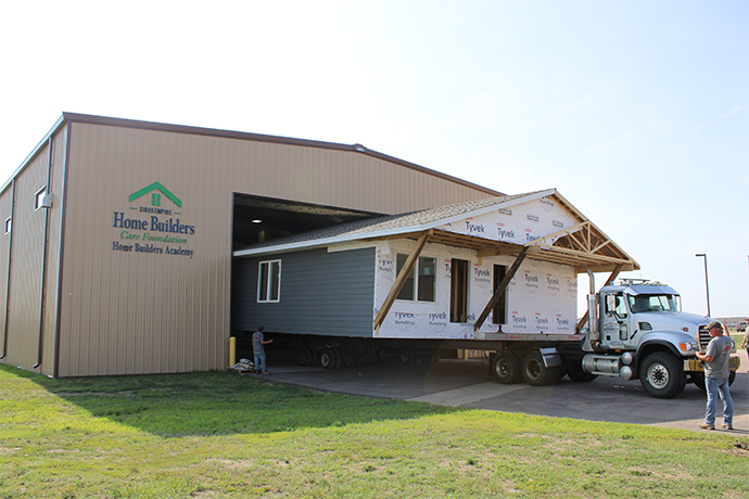 Ali and Rumiya's home is pulled out of the Harrisburg Home Builders Academy on a truck to be transported to Habitat's lot.