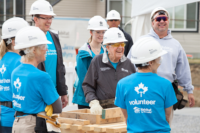 Jimmy Carter laughs with a group of volunteers at the Jimmy & Rosalynn Carter Work Project in 2017.