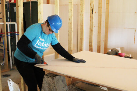 Dalonda, one of our future homebuyers, cuts firewall material.