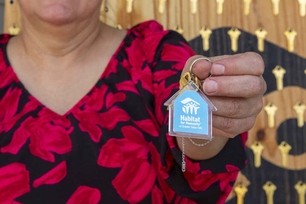 New homeowner Vickie holds up the new keys to her home.