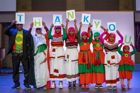 Habitat homeowners and their family holding up letters that spell "Thank You".