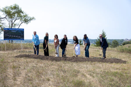 Habitat for Humanity and community leaders smile holding shovels of dirt at the Cliffview Heights groundbreaking.