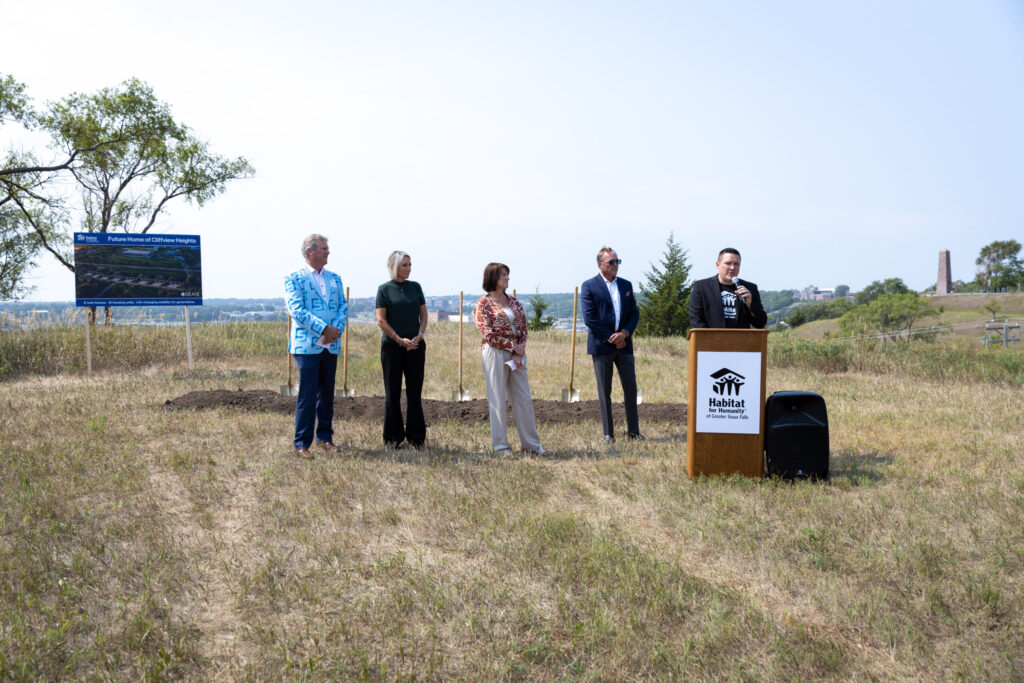 Habitat for Humanity Executive Director Rocky Welker speaks during the Cliffview Heights groundbreaking. Other Habitat and community leaders look on.