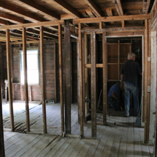 The house is free of drywall and insulation. You can see the studs of the house and the subfloor.