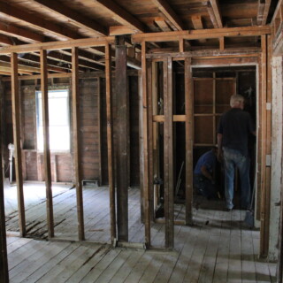 By the end of the week, the interior of the home was down to the studs! The house is free of drywall and insulation. You can see the studs of the house and the subfloor.