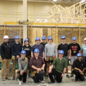 Construction students at CTE Academy who helped build this home during the 2023-24 school year. A group of students and instructors from CTE Academy smile in front of their partially constructed Habitat home.