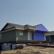 Through a meticulous process, the home is lined up and set onto the foundation. A partially completed home is raised above the foundation of the home.