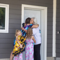 New homeowner Dalonda hugs Linda during the dedication after being presented with the keys to her home.