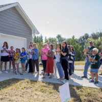 Attendees at the 200th Home Dedication celebration clap during the program.