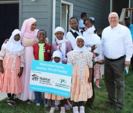 Thank you to First PREMIER Bank & PREMIER Bankcard and Federal Home Loan Bank of Des Moines for awarding us a $91,000 Member Impact Fund grant! A First PREMIER team member smiles with new Habitat homebuyers and their family on their home dedication day.
