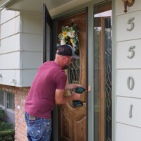 Our NR coordinator, Brad, even let us take his photo while installing a storm door! Habitat's NR coordinator drills the frame of a storm door into a home.