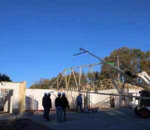 Volunteers assist in setting roof trusses on a Habitat twin home.