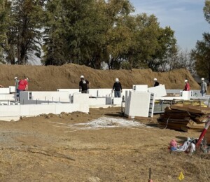 Volunteers stack ICF block to build walls for a Millard Acres twin home.