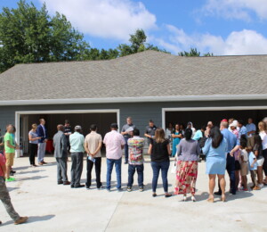 Habitat supporters gather for the dedication of four homes in Millard Acres.