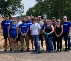 Metabank volunteers smile in the empty Millard Acres development before their volunteer shift.