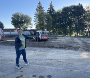 Future homebuyer Catie points to the empty lot where her home will be built