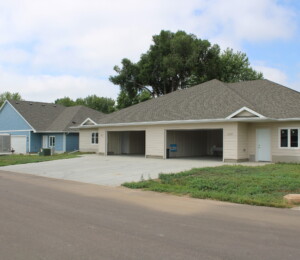 Photo of the exterior of two Millard Acres twin homes. One is blue and one is tan.