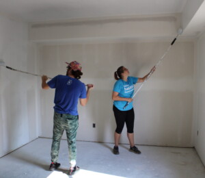 Future Habitat homebuyer Dalonda and another volunteer paint the interior of her Millard Acres twin home.