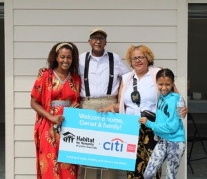 Genet hugs her family while holding a welcome home sign.