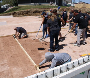 Habitat volunteers level dirt in a different twin home foundation.